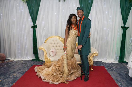 Bride and groom pose in front of chaise longue